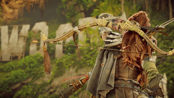 Aloy looking up at the ruined remains of the Hollywood sign in Horizon Forbidden West