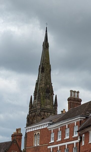 A Cathedral steeple with a long ladder going up to the top